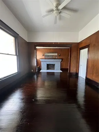 a living room with hardwood floor a ceiling fan and a window