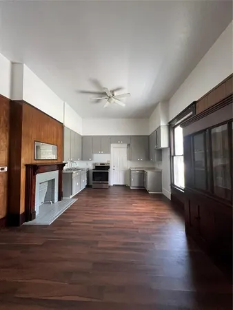 a view of a kitchen with a sink stove cabinets and empty room