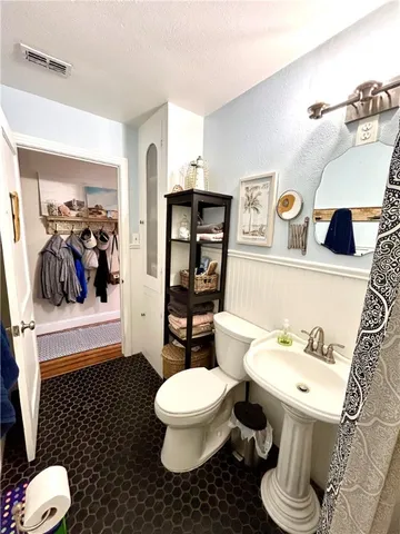 a white toilet sitting next to a bathroom sink and a mirror