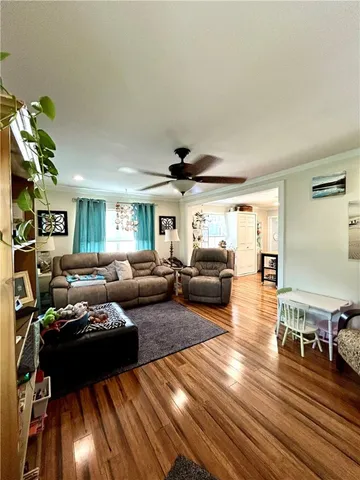 a living room with furniture and a wooden floor