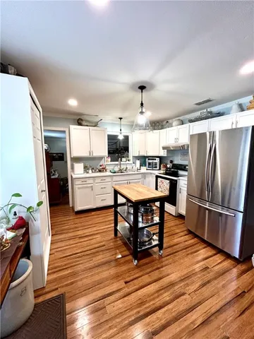 a kitchen with a table chairs refrigerator and microwave