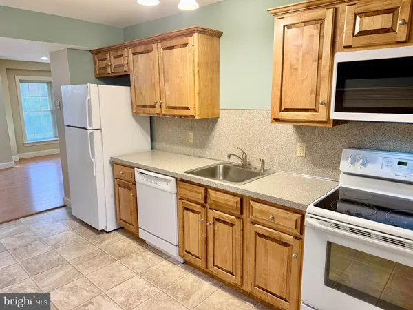 a kitchen with stainless steel appliances granite countertop a refrigerator sink and stove