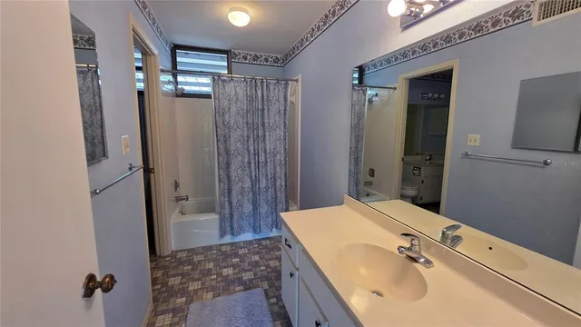 a bathroom with a sink mirror and shower