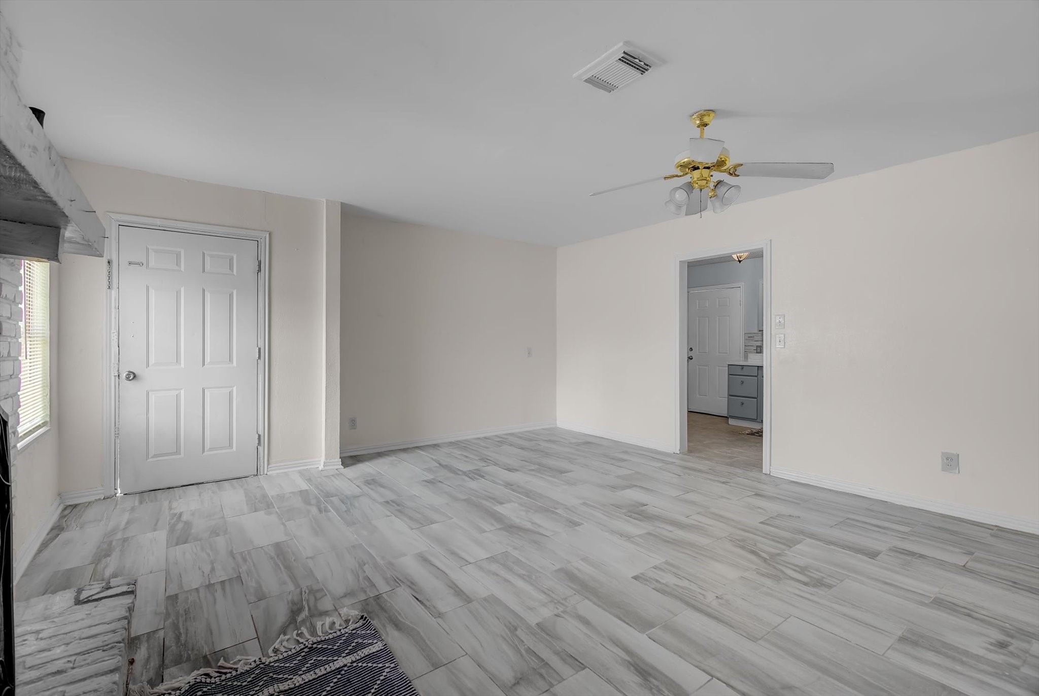 418 Azalea Street Lake Jackson, TX 77566 - Photo 10 of 34 Spacious and inviting living area featuring stylish flooring, a ceiling fan, and abundant natural light—perfect for relaxation and entertaining.
