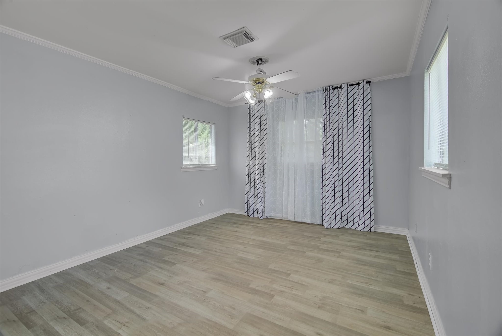 418 Azalea Street Lake Jackson, TX 77566 - Photo 14 of 34 an empty room with wooden floor ceiling fan and windows