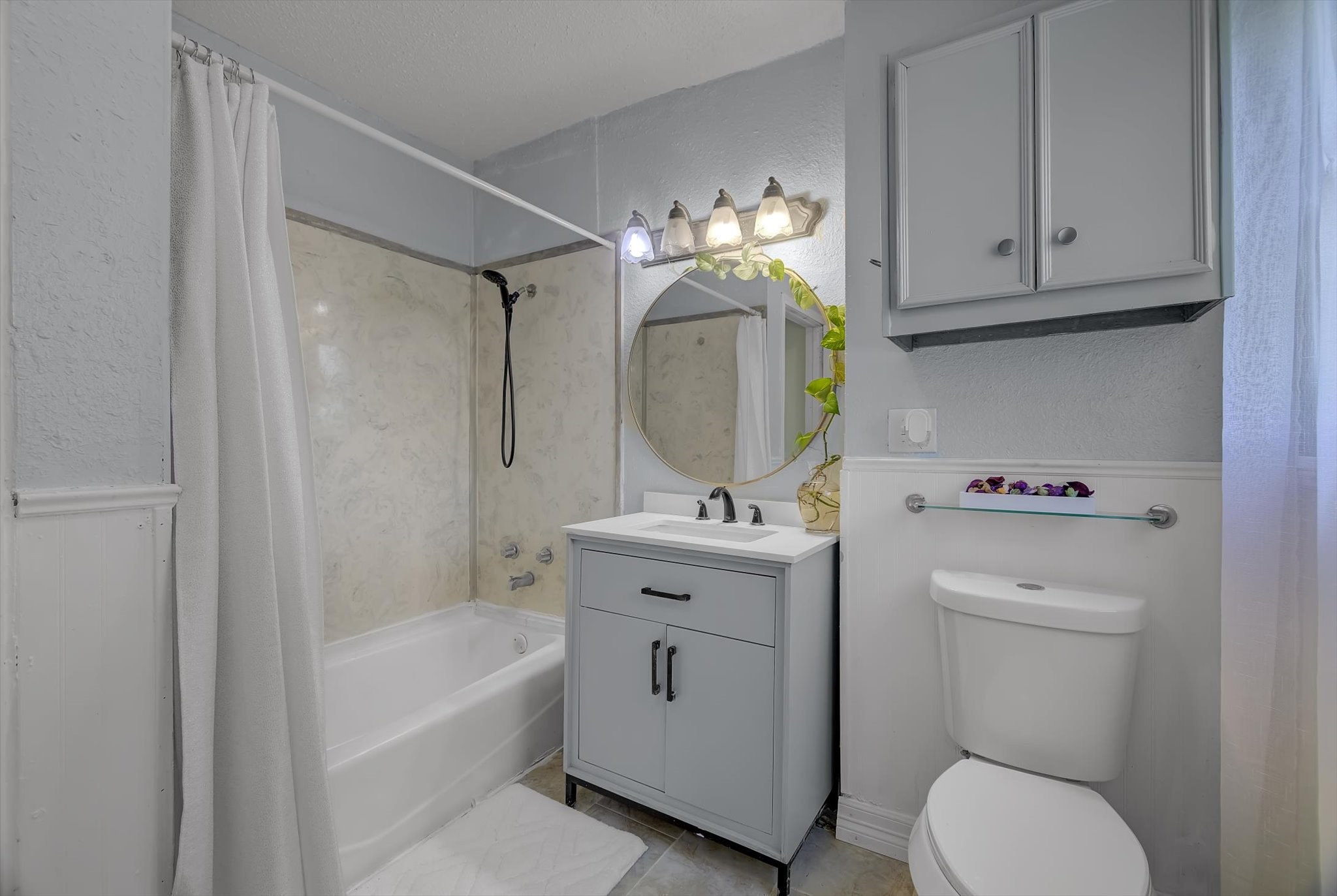 418 Azalea Street Lake Jackson, TX 77566 - Photo 28 of 34 Modern and inviting, this bathroom features a sleek vanity with ample storage, a classic tub-shower combo, and elegant lighting. Perfect for relaxation and functionality.