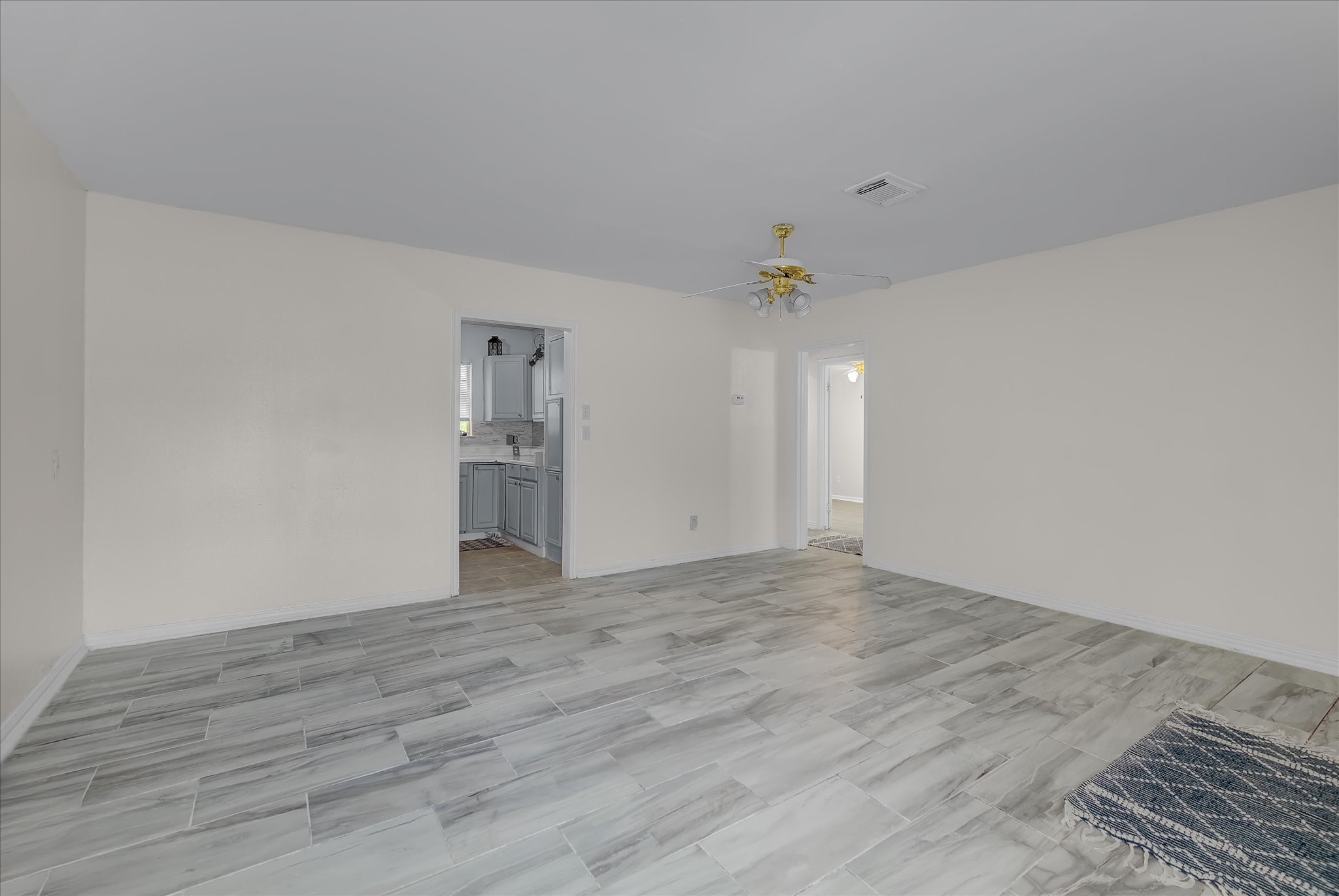 418 Azalea Street Lake Jackson, TX 77566 - Photo 5 of 34 a view of an empty room with wooden floor and a kitchen