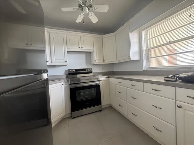 a kitchen with cabinets appliances and a window