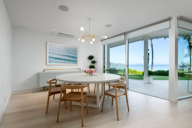 a dining room with furniture a chandelier and wooden floor