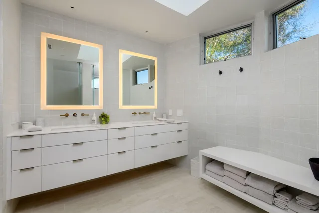 a bathroom with a sink mirror and a toilet