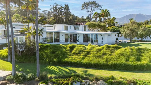 a view of a house with a big yard and potted plants
