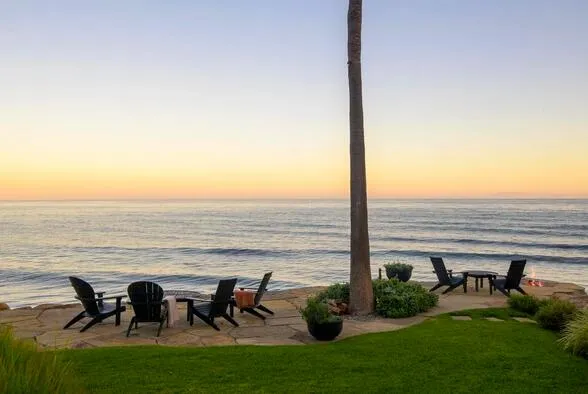 a group of chairs sitting in the patio next to a yard