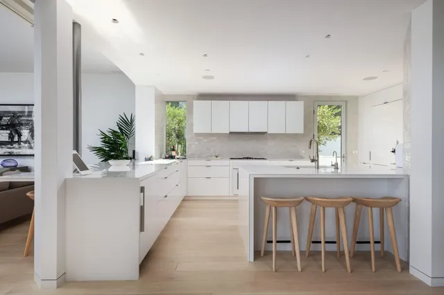 a kitchen with white cabinets and sink
