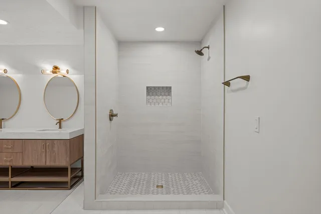 a bathroom with a mirror a bathtub and shower