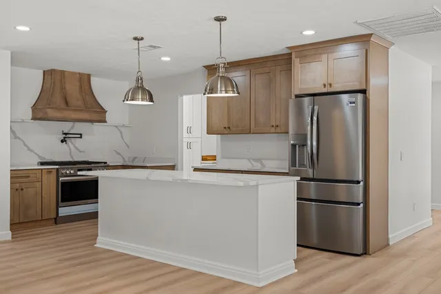 a kitchen with kitchen island a counter top space stove and refrigerator