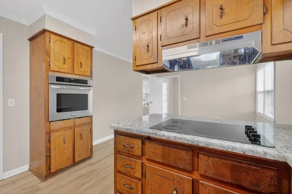 a kitchen with granite countertop cabinets stainless steel appliances a sink and wooden floor