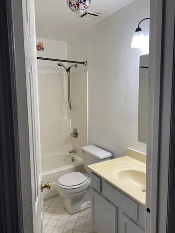 a bathroom with a granite countertop sink a toilet and shower