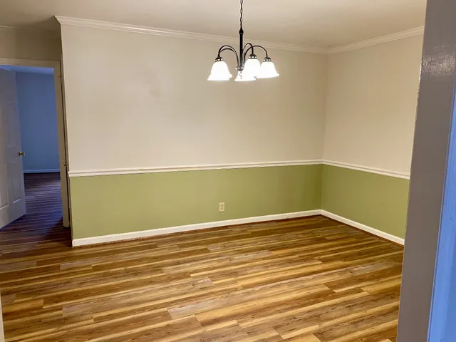 a view of a room with wooden floor and white walls