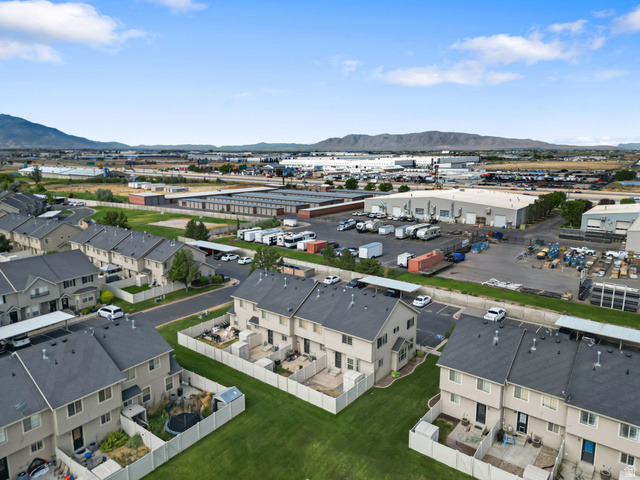 983 South 1850th Street West Springville, UT 84663 - Photo 27 of 30 Aerial perspective showcasing a residential development with individual fenced yards and adjacent commercial structures