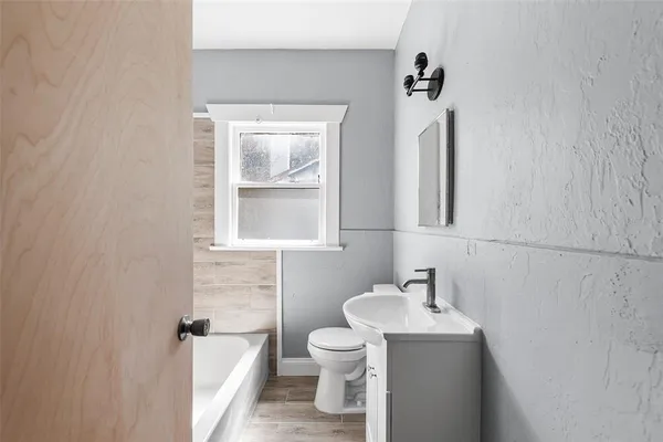 a bathroom with a toilet sink and mirror