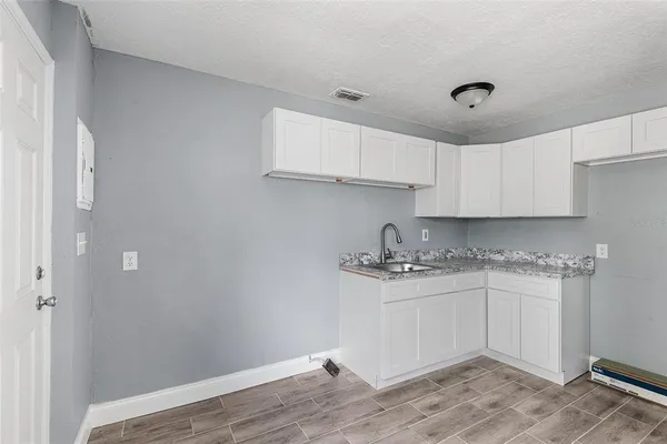 a kitchen with a sink cabinets and wooden floor