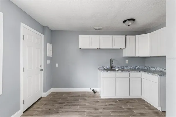 a kitchen with granite countertop a sink and cabinets