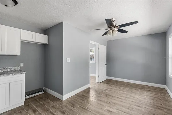 a view of a livingroom with wooden floor and a ceiling fan