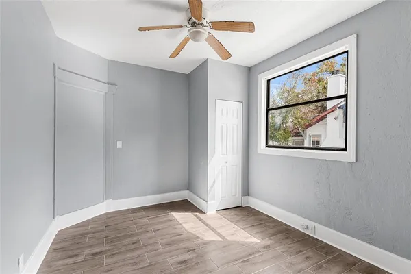 a view of an empty room with window and closet area