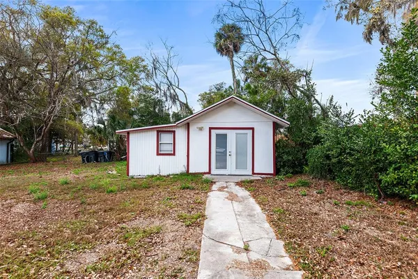 a front view of a house with a yard and trees