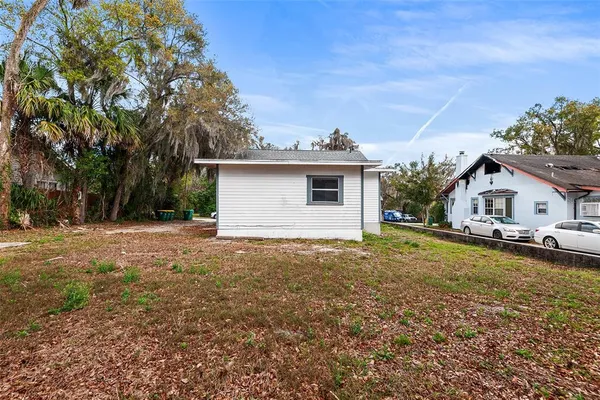a view of house with yard and swimming pool