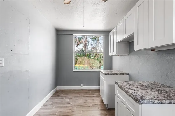 a kitchen with a granite countertop sink window and refrigerator