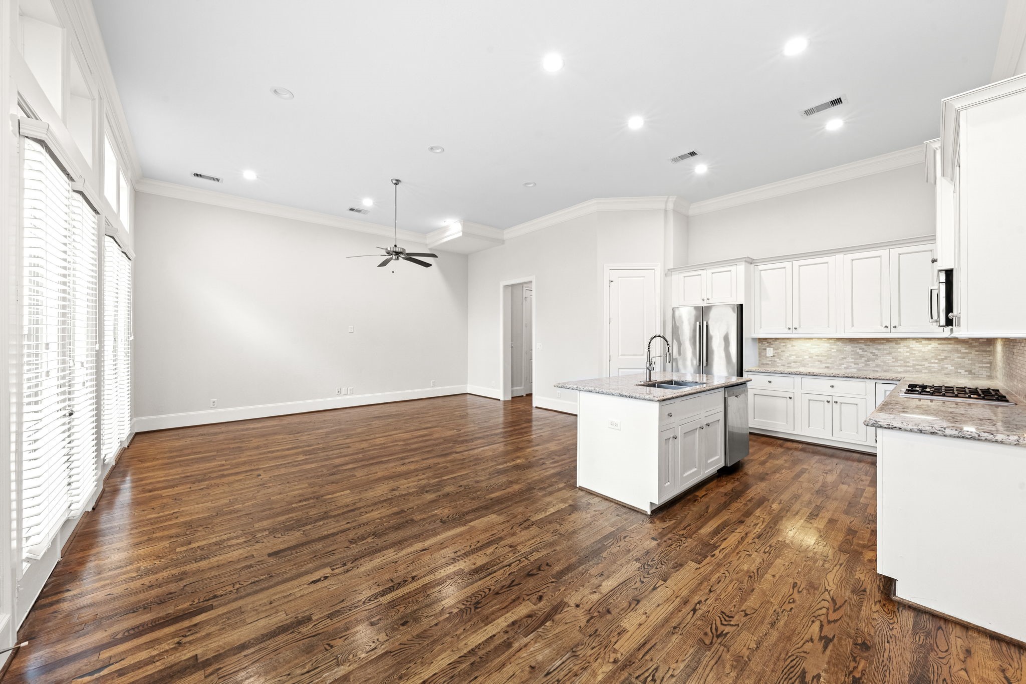 5621 Cohn Meadow Lane Houston, TX 77007 - Photo 6 of 35 Light-filled first-floor living space with soaring ceilings, rich hardwood floors, and seamless open-concept design connecting the kitchen and dining areas.