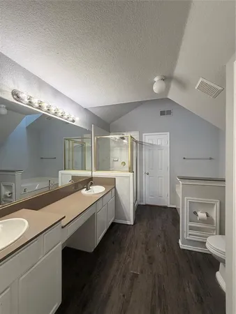 a large white kitchen with a sink and wooden floor