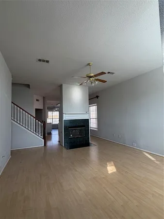 a view of empty room with fireplace and wooden floor