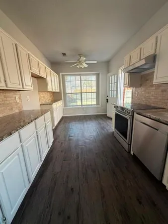 a view of a kitchen with wooden floor and electronic appliances