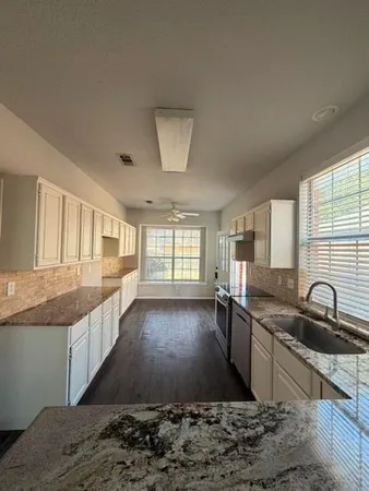 a large kitchen with granite countertop a large window