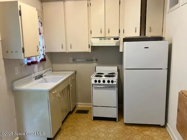a kitchen with kitchen island sink refrigerator and cabinets