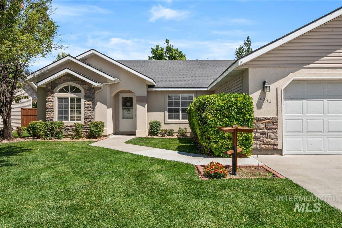 2032 Talus Loop Twin Falls, ID 83301 - Photo 1 of 43 Stucco and stone facade with arched entry, arched window, attached garage, and manicured landscaping
