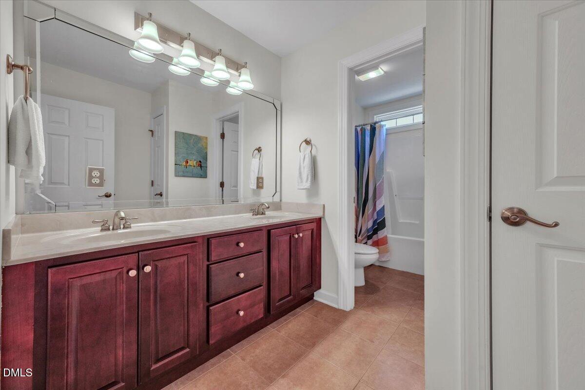 2908 Oak Bridge Drive Raleigh, NC 27610 - Photo 32 of 47 a bathroom with a double vanity sink double vanity and a mirror