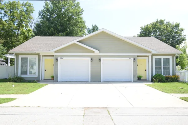 a front view of a house with a garden
