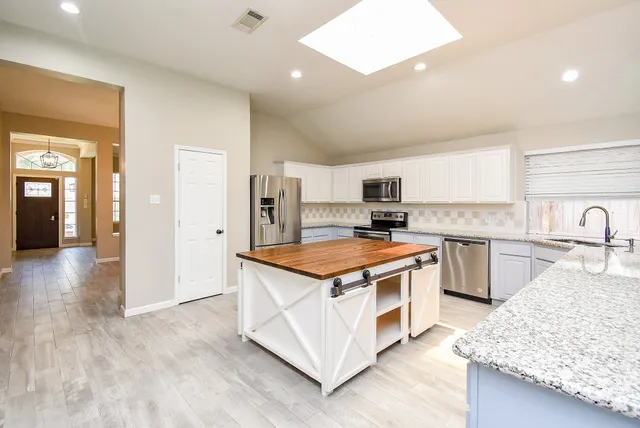 a kitchen with stainless steel appliances granite countertop a stove and a sink
