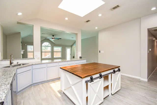 a kitchen with a sink and wooden floor