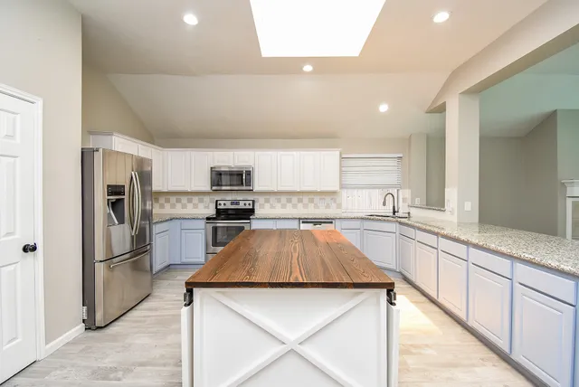 a kitchen with white cabinets and stainless steel appliances