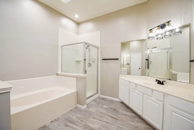 a bathroom with a tub sink and mirror