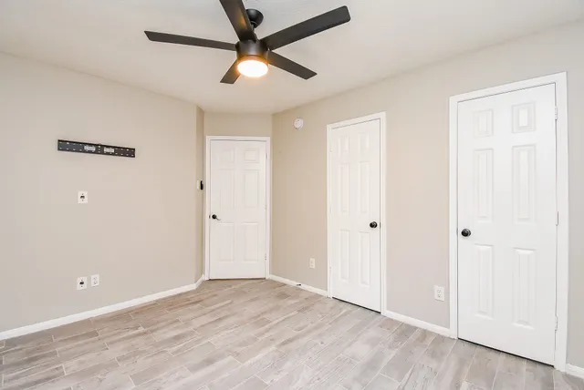 an empty room with wooden floor and windows