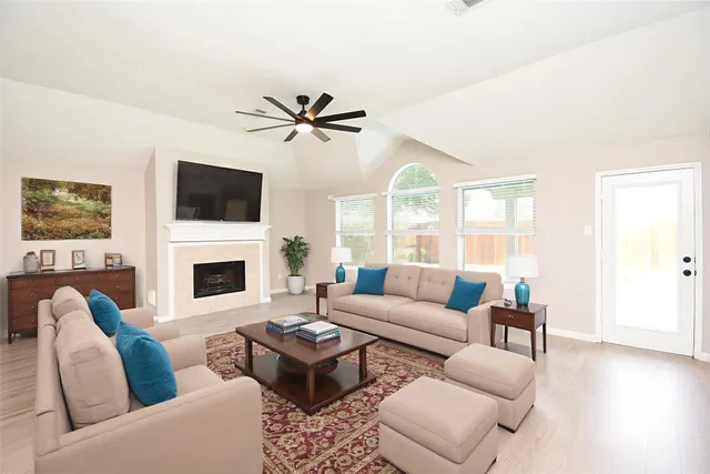 a living room with furniture a fireplace and a flat screen tv