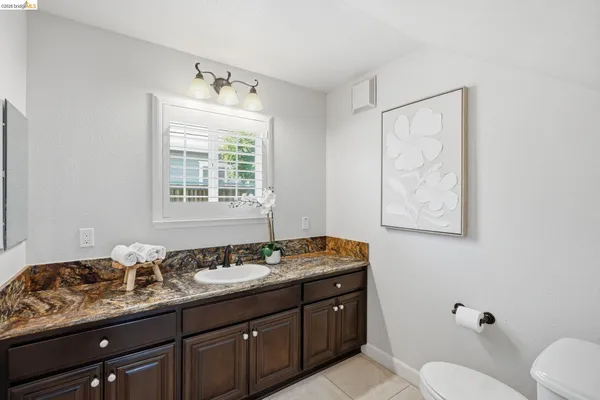 a bathroom with a granite countertop sink and a mirror