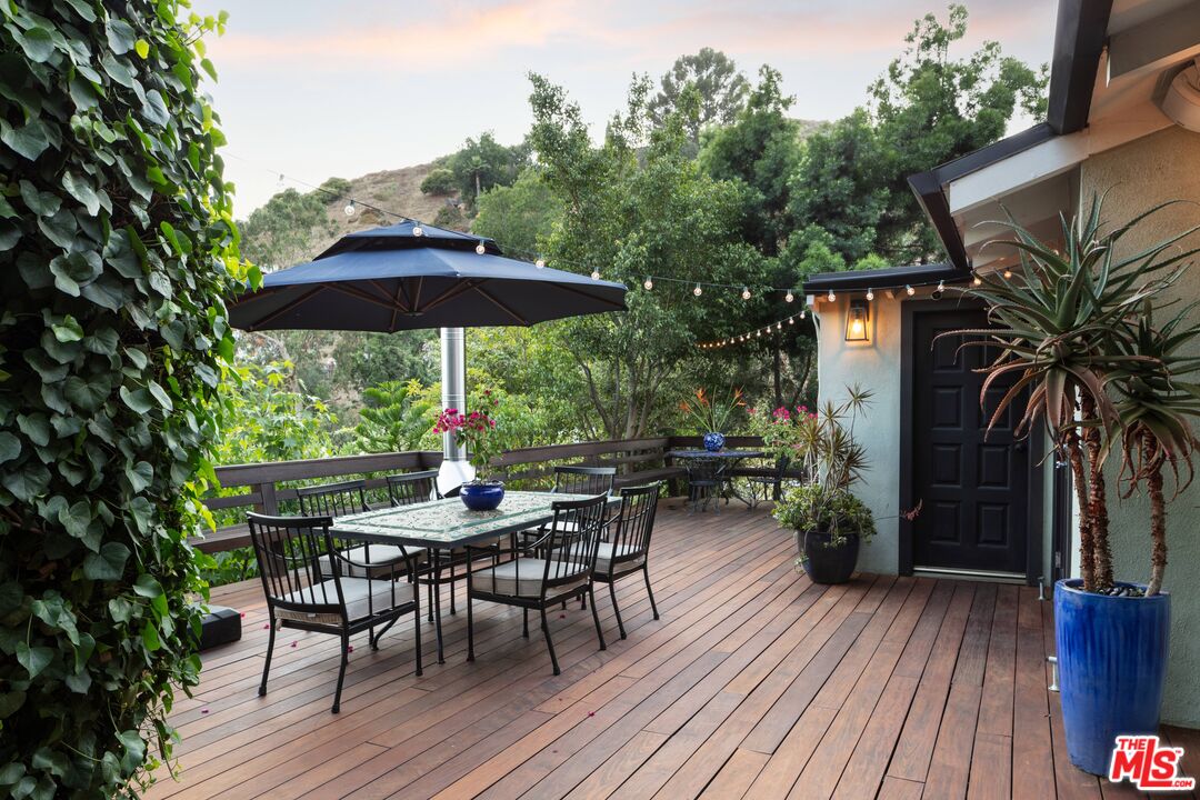6464 Bryn Mawr Drive Los Angeles, CA 90068 - Photo 18 of 23 a patio with wooden floor a yard a table and chairs