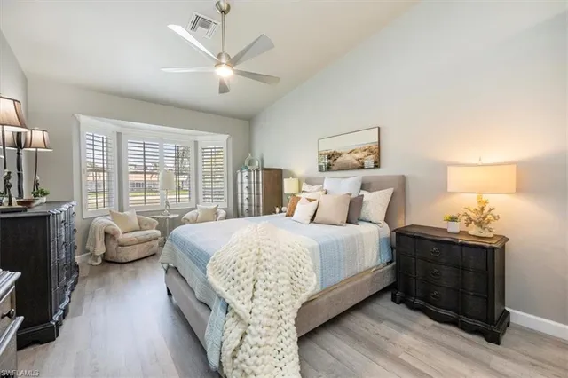 a spacious bedroom with a bed and wooden floor