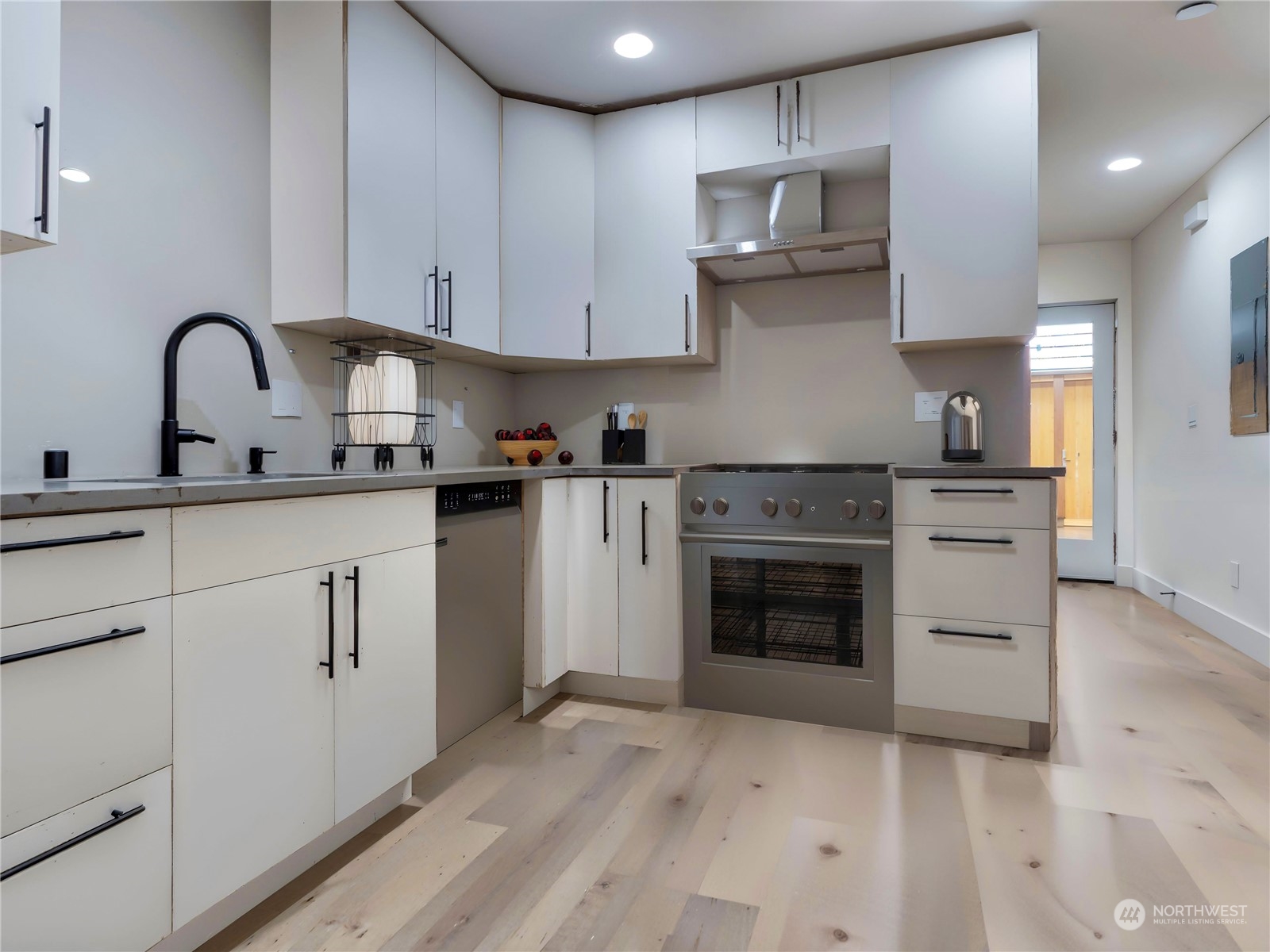 407 Southwest Thistle Street Seattle, WA 98106 - Photo 11 of 40 a kitchen with stainless steel appliances granite countertop a stove sink and cabinets
